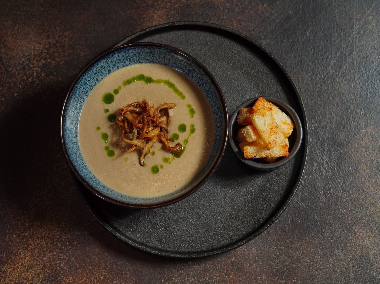 Cremet suppe med stegte løg, grøn olie og sprøde brødterninger